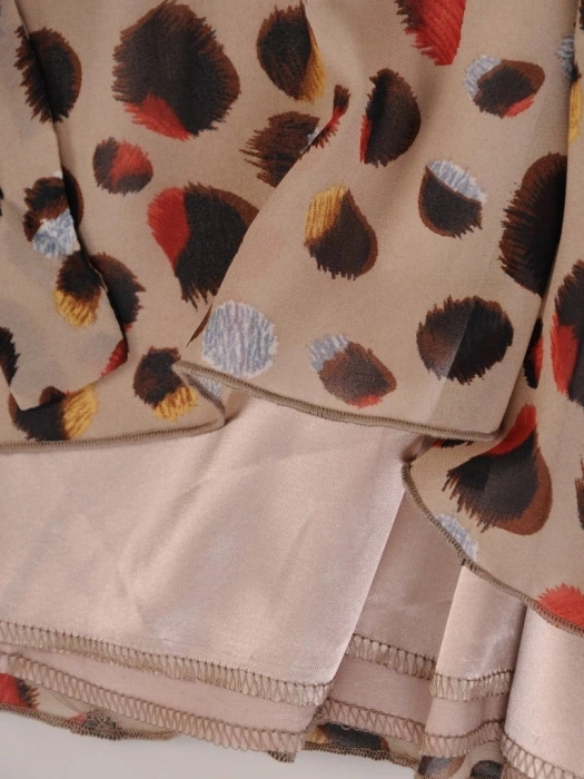 Beżowa sukienka trapezowa midi w kropki – tuszujący fason z urokliwą falbaną 25625