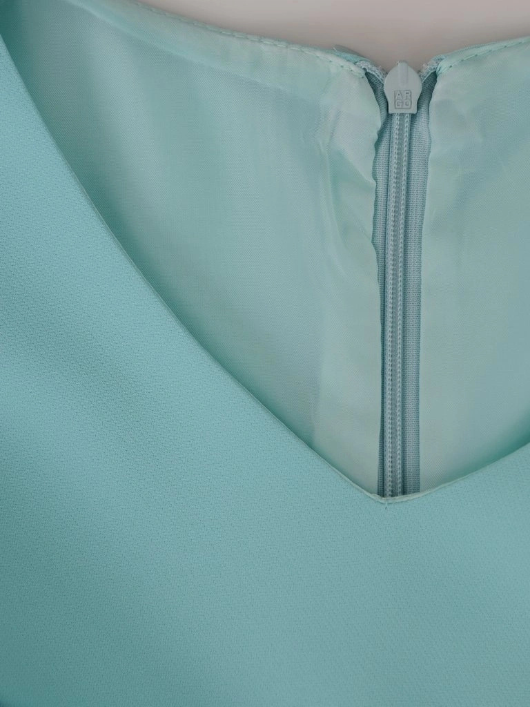 Elegancka sukienka trapezowa w odcieniu mięty – kobiecy krój tuszujący biodra z falbanką 15579